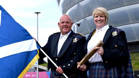 Alex Marshall and Sarah Adlington with Scottish flag and King's Baton
