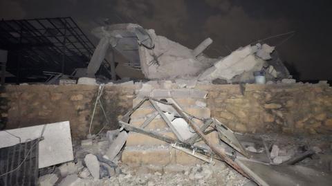 Rubble sits atop a small brick wall and six stairs.