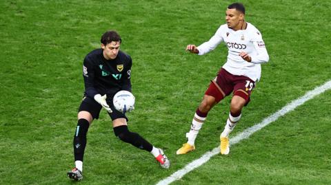 Oxford United's Jamie Cumming (left) gathers the ball under pressure from Bradford City striker Kayden Jackson