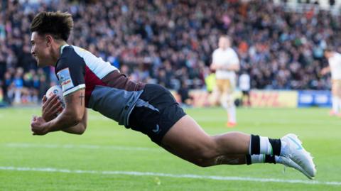 Marcus Smith dives over the line for the opening Harlequins try against Saracens