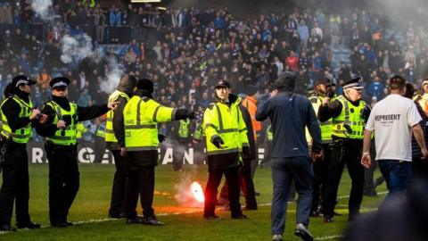 Fans from both sides ran on to the pitch at Ibrox in March