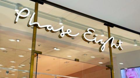 Phase Eight sign hangs above a glass storefront in London