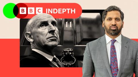 A black and white head and shoulders photo of John healey with the Downing Street door behind him. Faisal Islam is to the right of frame.