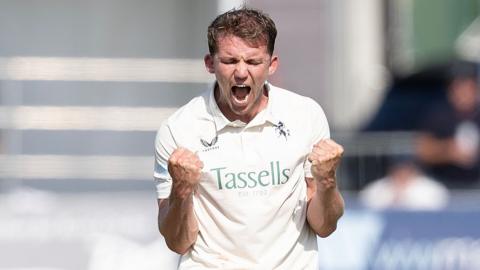 Matt Milnes in white with a double fist pump celebration