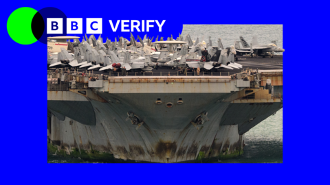 A photo of the the bottom half of the USS Lincoln with rust and algae on it, with war planes on top of the deck.