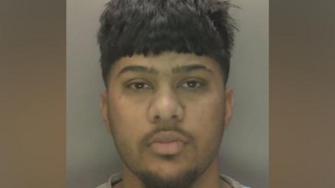 A custody image shows a man with short brown hair, a full fringe, and a goatee beard.
