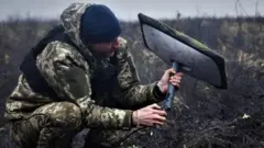 Український військовий встановлює термінал супутникового зв'язку Starlink на позиції в Донецькій області, Україна, 16 жовтня 2026 року.