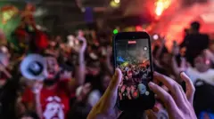 Избиратель снимает на мобильный телефон победный митинг сторонников президента да Силвы