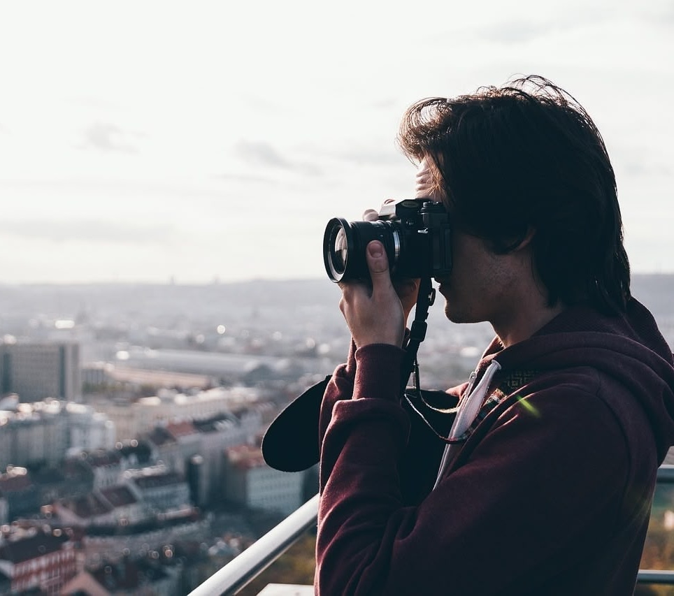 屋上から街の写真を撮っている男性