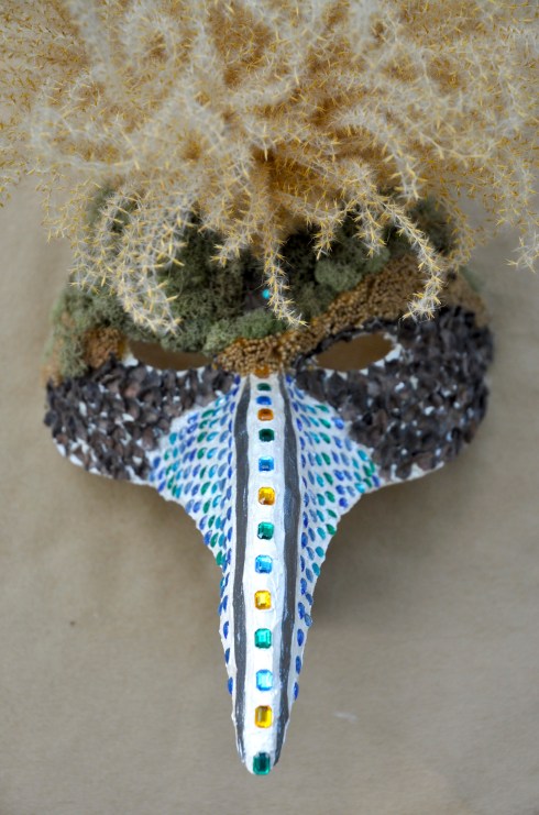 Papier mâché, grass, persimmon caps, moss and glass.
