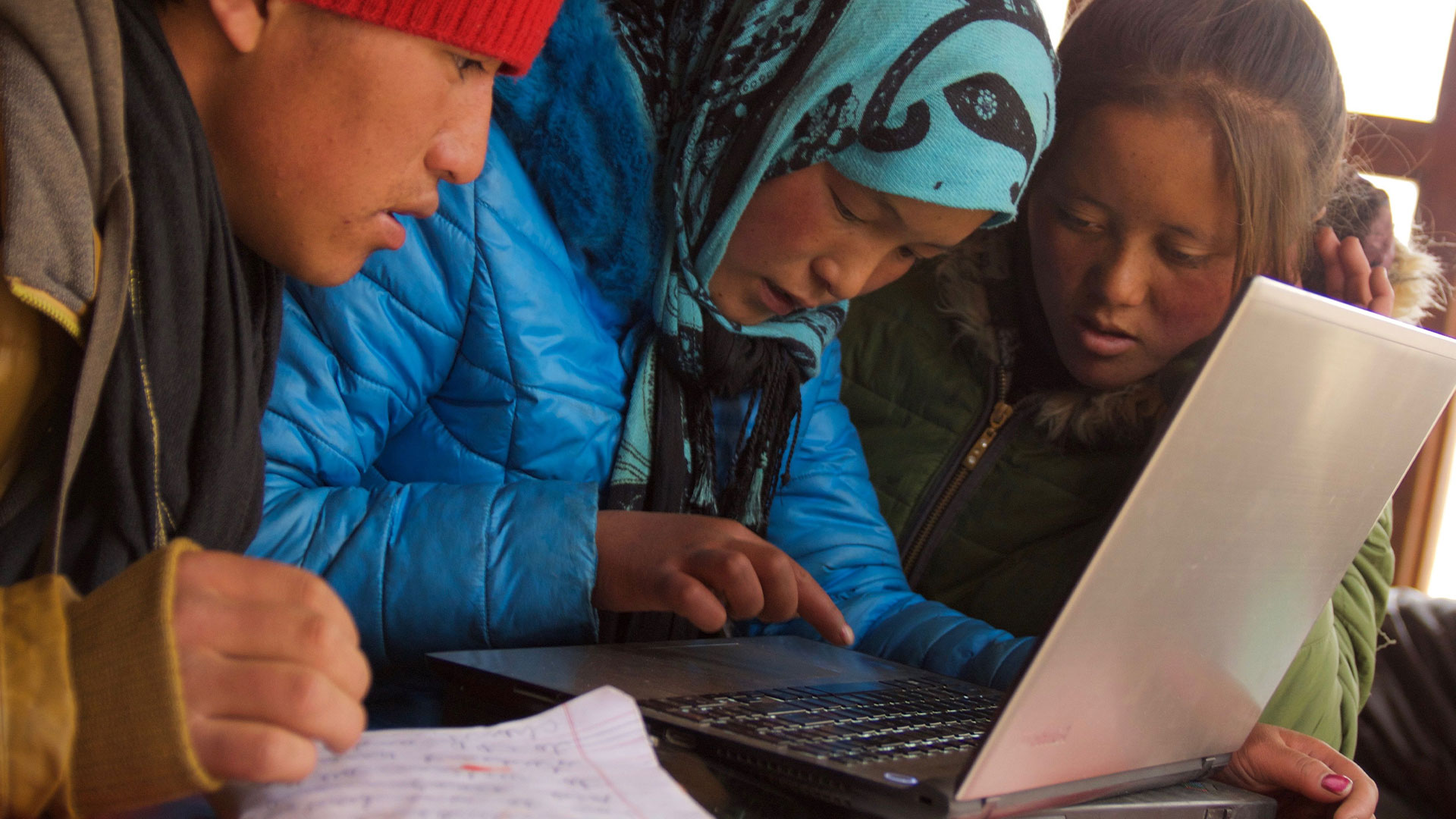 3 people in Mongolia using a laptop