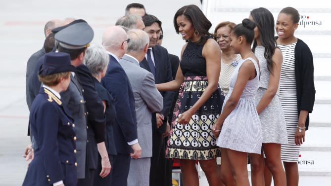 U.S. first lady Michelle Obama (C) greets local authorities as she arrives with her daughters Sasha and Malia at Malpensa airport in Milan, Italy, as part of her European trip June 17, 2015. REUTERS/Alessandro Garofalo