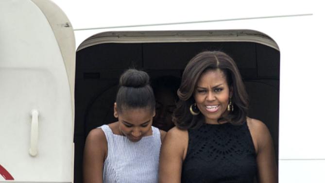 U.S. first lady Michelle Obama, right, and her daughter Sasha disembark from a plane as they arrive at Malpensa airport in Milan, Italy, Wednesday, June 17, 2015. Michelle Obama has arrived in Milan on the second leg of a European trip that puts an international spin on her core initiatives. (AP Photo/Giuseppe Aresu)