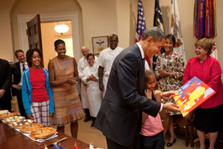 President Barack Obama, with daughter Sasha, looks at the card given to him during a birthday party with his staff in the Roosevelt Room of the White House, August 4, 2009. Daughter Malia nd First Lady Michelle Obama look on at left. (Official White House Photo by Pete Souza) This official White House photograph is being made available only for publication by news organizations and/or for personal use printing by the subject(s) of the photograph. The photograph may not be manipulated in any way and may not be used in commercial or political materials, advertisements, emails, products, promotions that in any way suggests approval or endorsement of the President, the First Family, or the White House.