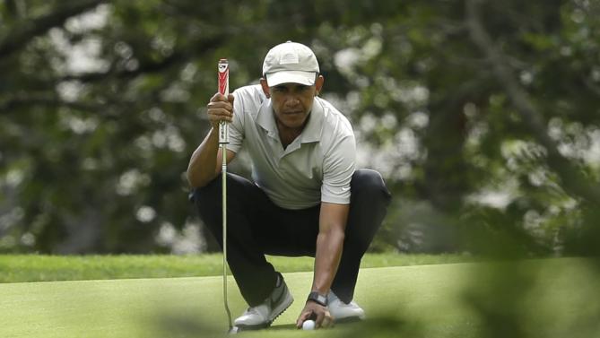 President Barack Obama places his ball on the green before putting while golfing Sunday, Aug. 23, 2015, at Farm Neck Golf Club, in Oak Bluffs, Mass., on the island of Martha's Vineyard. (AP Photo/Steven Senne)