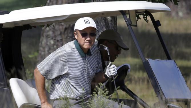 World Bank President Jim Yong Kim, front, steps out of a golf cart driven by President Barack Obama, behind, while golfing at Vineyard Golf Club, in Edgartown, Mass., on the island of Martha's Vineyard, Monday, Aug. 10, 2015. The president is staying on Martha's Vineyard with first lady Michelle Obama and daughter Sasha for a 17-day island retreat. (AP Photo/Steven Senne)