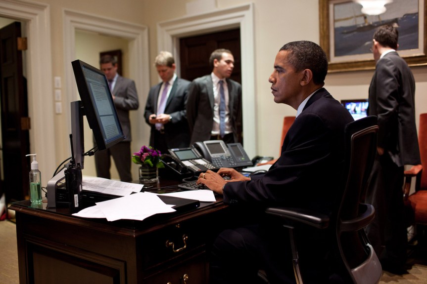 President Barack Obama works on his statement on the compromise reached to reduce the deficit and avert a default, in the Outer Oval Office, Aug. 2, 2011. Standing in the background are, from left: Director of Communications Dan Pfeiffer; Press Secretary Jay Carney; Jon Lovett, Associate Director of Speechwriting; and Senior Advisor David Plouffe. (Official White House Photo by Pete Souza) This official White House photograph is being made available only for publication by news organizations and/or for personal use printing by the subject(s) of the photograph. The photograph may not be manipulated in any way and may not be used in commercial or political materials, advertisements, emails, products, promotions that in any way suggests approval or endorsement of the President, the First Family, or the White House.