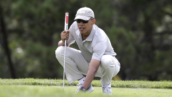 President Barack Obama places the ball on the green before putting while golfing Saturday, Aug. 8, 2015, at Farm Neck Golf Club, in Oak Bluffs, Mass., on the island of Martha's Vineyard. Obama is spending his first full day of vacation on the island playing golf. (AP Photo/Steven Senne)