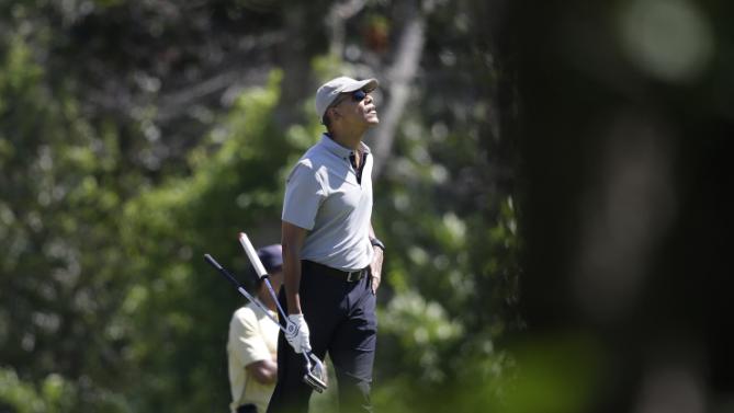 President Barack Obama looks up as he walks across a green while golfing, Wednesday, Aug. 12, 2015, at Farm Neck Golf Club, in Oak Bluffs, Mass., on the island of Martha's Vineyard. The president, first lady Michelle Obama, and daughter Sasha are vacationing on the island. (AP Photo/Steven Senne)