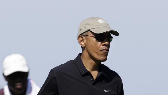 President Barack Obama carries a club as he walks toward a green while golfing Monday, Aug. 10, 2015, at Vineyard Golf Club, in Edgartown, Mass., on the island of Martha's Vineyard. The president is staying on Martha's Vineyard with first lady Michelle Obama and daughter Sasha for a 17-day island retreat. (AP Photo/Steven Senne)