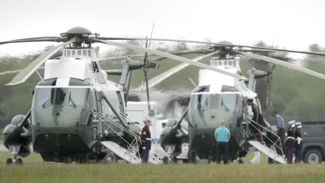 President Barack Obama, third from right, and first lady Michelle Obama, fourth from right, board Marine One, Sunday, Aug. 23, 2015, at an airfield in Edgartown, Mass., on the island of Martha's Vineyard. The President and his family departed the island Sunday following a vacation that was over two weeks in length. (AP Photo/Steven Senne)