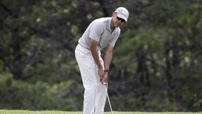 President Barack Obama putts while golfing Saturday, Aug. 8, 2015, at Farm Neck Golf Club, in Oak Bluffs, Mass., on the island of Martha's Vineyard. Obama is spending his first full day of vacation on the island playing golf. (AP Photo/Steven Senne)
