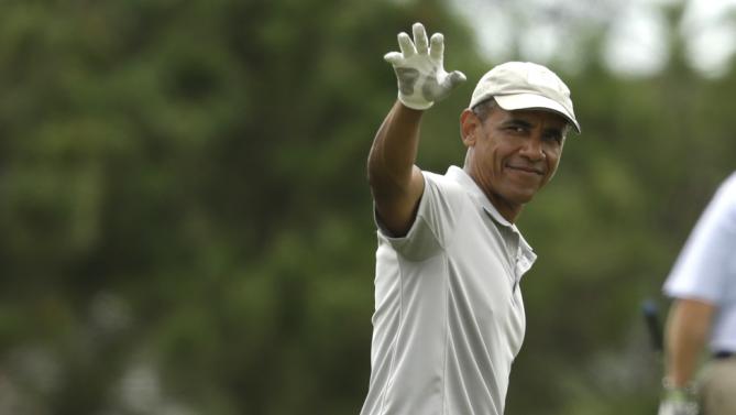 President Barack Obama waves while golfing Sunday, Aug. 23, 2015, at Farm Neck Golf Club, in Oak Bluffs, Mass., on the island of Martha's Vineyard. The president spent most of his two-week summer vacation on the golf course, at the beach, and dining out with his family. (AP Photo/Steven Senne)