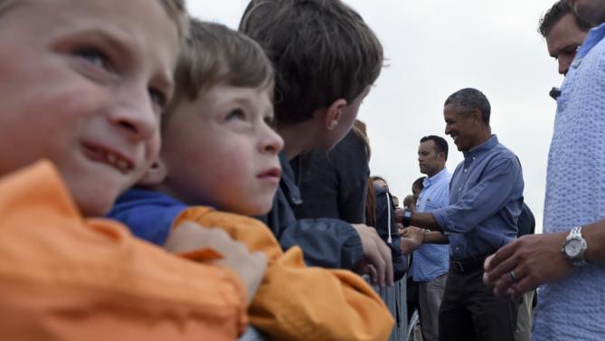 President Barack Obama greets people before boarding Air Force One at Air Station Cape Cod, in Mass., Sunday, Aug. 23, 2015. The president is returning to Washington after he and his family spent more than two weeks vacationing on the Massachusetts island of Martha's Vineyard. (AP Photo/Susan Walsh)