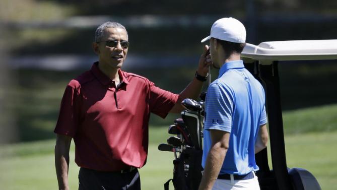 President Barack Obama speaks with NBA basketball player Stephen Curry while golfing, Friday, Aug. 14, 2015, at Farm Neck Golf Club, in Oak Bluffs, Mass., on the island of Martha's Vineyard. The president, first lady Michelle Obama, and daughter Sasha are vacationing on the island. (AP Photo/Steven Senne)