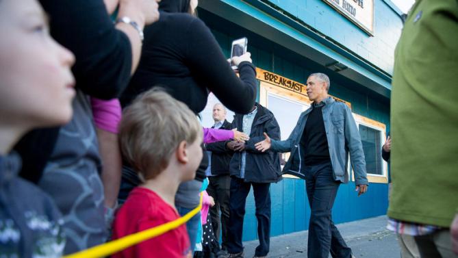 President Barack Obama greets people in downtown Seward, Alaska, Tuesday, Sept. 1, 2015, after takes a hike to view the Exit Glacier. Obama is on a historic three-day trip to Alaska aimed at showing solidarity with a state often overlooked by Washington, while using its glorious but changing landscape as an urgent call to action on climate change. (AP Photo/Andrew Harnik)