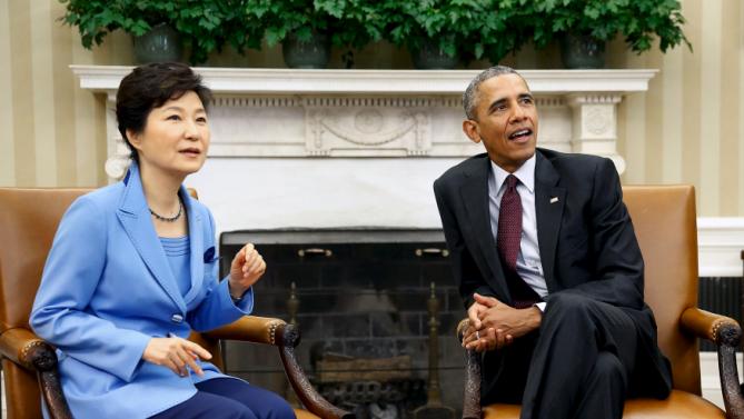 U.S. President Barack Obama (R) and South Korea's President Park Geun-hye react to jostling South Korean media as they sit down for their meeting in the Oval Office the White House in Washington, October 16, 2015. REUTERS/Jonathan Ernst