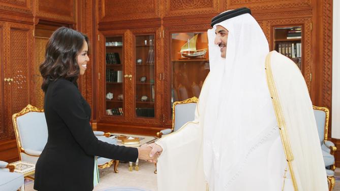 In this photo made available by the Qatar News Agency, QNA, U.S. First Lady Michelle Obama shakes hands with Qatar Emir Sheik Tamim bin Hamad Al-Thani in Doha, Qatar, Tuesday, Nov. 3, 2015. (Qatar Government/QNA via AP)