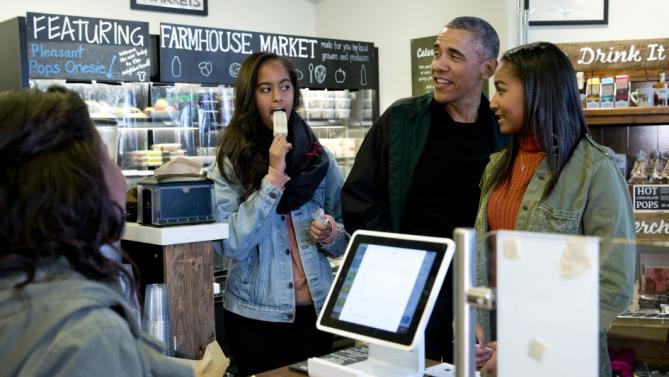President Barack Obama, joined by his daughters Malia, left, and Sasha, right, orders at Pleasant Pops on Small Business Saturday in Washington, Saturday, Nov. 28, 2015. (AP Photo/Carolyn Kaster)