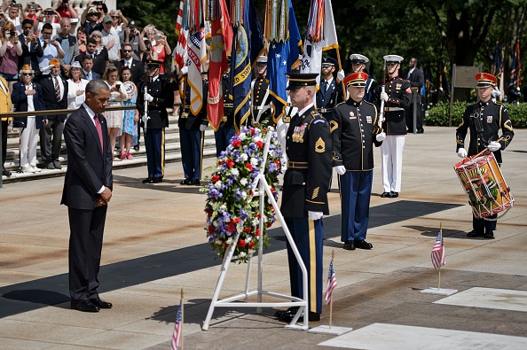 US President Barack Obama (L) bows his head after placing a wreath at the Tomb of the Unknowns to honor Memorial Day at Arlington National Cemetery May 30, 2016 in Arlington, Virginia. / AFP / Brendan Smialowski (Photo credit should read BRENDAN SMIALOWSKI/AFP/Getty Images)