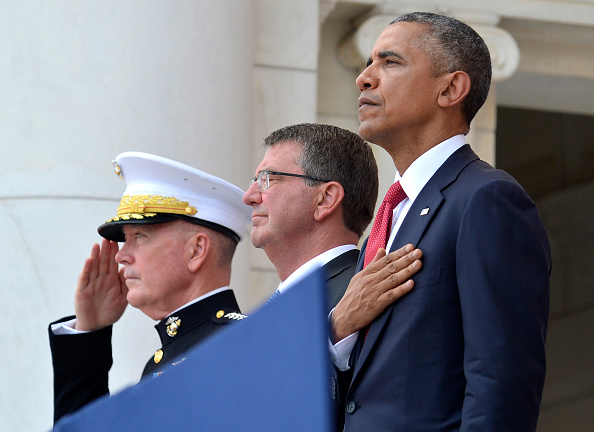 ARLINGTON, VA - MAY 30: (AFP-OUT) President Barack Obama, Chairman of the Joint Chiefs of Staff Gen. Joseph Dunford (L) and Defense Secretary Ashton Carter (C) listen to the National Anthem at the conclusion of remarks at Arlington National Cemetery on May 30, 2016 in Arlington, Virginia. Obama paid tribute to the nation's fallen military service members. (Photo by Mike Theiler-Pool/Getty Images)