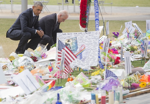 US President Barack Obama and Vice President Joe Biden pause after laying flowers for the victims of the mass shooting at a gay nightclub Sunday at a memorial at the Dr. Phillips Center for the Performing Arts in Orlando, Florida, June 16, 2016. / AFP / SAUL LOEB (Photo credit should read SAUL LOEB/AFP/Getty Images)