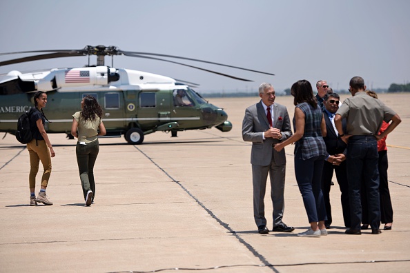 Malia Obama (L) and Sasha Obama walk to a helicopter while looking back at US First Lady Michelle Obama and US President Barack Obama as they greet officials at Roswell International Air Center June 17, 2016 in Roswell, New Mexico. / AFP / Brendan Smialowski (Photo credit should read BRENDAN SMIALOWSKI/AFP/Getty Images)