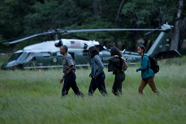 US President Barack Obama with first lady Michelle Obama and their daughters Sasha and Malia (R) walk through Ahwahnee Meadow after arriving on Marine One June 17, 2016 in Yosemite Vally, California. / AFP / Brendan Smialowski (Photo credit should read BRENDAN SMIALOWSKI/AFP/Getty Images)