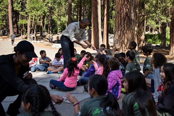US First Lady Michelle Obama (L) and US President Barack Obama hand out National Park passes to children for the "Every Kid in the Park" initiative in Yosemite National Park, California, while celebrating the 100th year of US National Parks June 18, 2016. / AFP / Brendan Smialowski (Photo credit should read BRENDAN SMIALOWSKI/AFP/Getty Images)