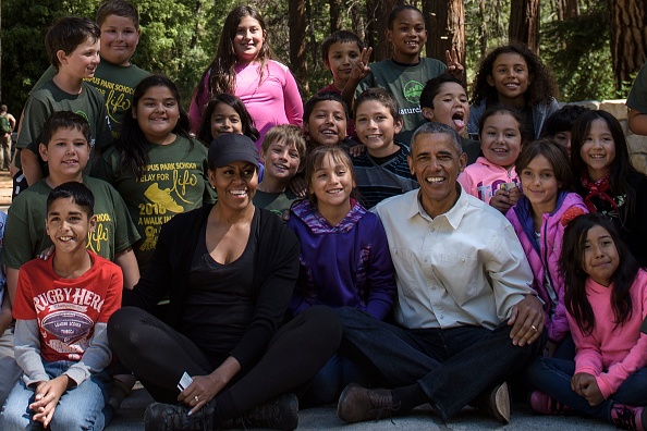 US First Lady Michelle Obama and US President Barack Obama pose with children after speaking to them about the "Every Kid in the Park" initiative in Yosemite National Park, California, while celebrating the 100th anniversary of the US National Parks June 18, 2016. / AFP / Brendan Smialowski (Photo credit should read BRENDAN SMIALOWSKI/AFP/Getty Images)