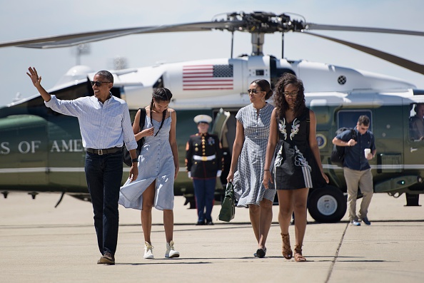 From left: US President Barack Obama, daughter Malia Obama, US first lady Michelle Obama, and daughter Sasha Obama walk to Air Force One at Castle Airport June 19, 2016 in Merced County, California. / AFP / Brendan Smialowski (Photo credit should read BRENDAN SMIALOWSKI/AFP/Getty Images)
