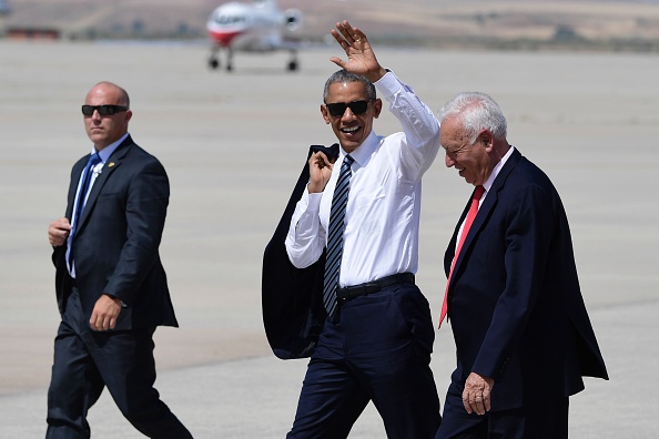 US president Barack Obama (C) waves past Spanish Minister of Foreign Affairs and Cooperation Jose Garcia-Margallo (R), on his way to his plane at Torrejon de Ardoz airport on July 10, 2016. Obama said he will cut short a foreign trip and visit Dallas next week as the shooting rampage by the black army veteran, who said he wanted to kill white cops, triggered urgent calls to mend troubled race relations in the United States. / AFP / JAVIER SORIANO (Photo credit should read JAVIER SORIANO/AFP/Getty Images)