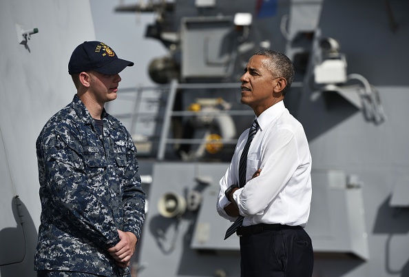 US President Barack Obama (R) chats with a soldier as he tours the USS Ross Navy ship at the Naval Station Rota, in Rota, southwestern Spain on July 10, 2016. Obama said he will cut short a foreign trip and visit Dallas next week as the shooting rampage by the black army veteran, who said he wanted to kill white cops, triggered urgent calls to mend troubled race relations in the United States. / AFP / Mandel Ngan (Photo credit should read MANDEL NGAN/AFP/Getty Images)