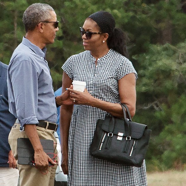 US President Barack Obama and First Lady Michelle Obama chat while waiting for their daughters Malia and Sasha to board Marine One at Martha's Vineyard airport in Edgartown, Massachusetts, on August 21, 2016 as they depart for Washington after a two-week holiday on the island. / AFP / NICHOLAS KAMM (Photo credit should read NICHOLAS KAMM/AFP/Getty Images)