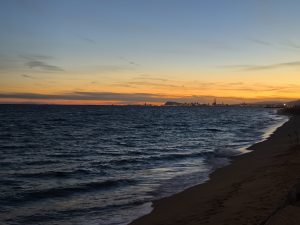A peaceful Barcelona beach at sunset with gentle waves.