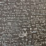 Uma imagem mostra um quadro cheio de equações matemáticas, fórmulas e anotações manuscritas. • SciELO em Perspectiva | Press Releases Uma imagem mostra um quadro cheio de equações matemáticas, fórmulas e anotações manuscritas.