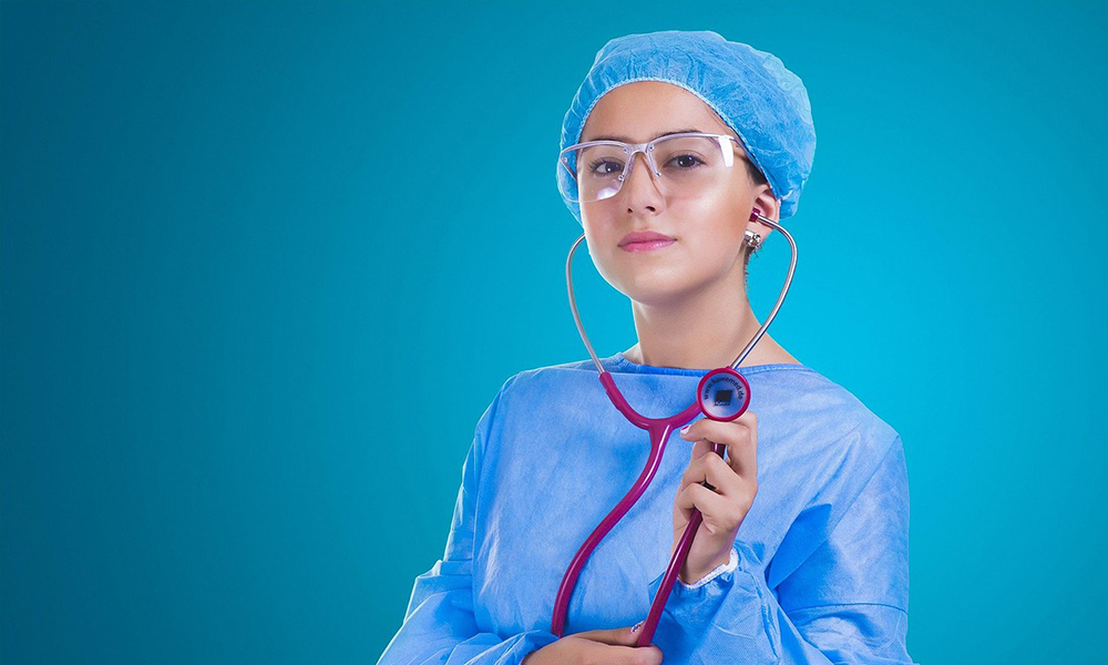 Photograph of a woman in scrubs holding a stethoscope Photograph of a woman in scrubs holding a stethoscope