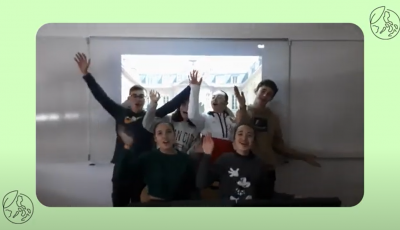 A group of 6 middle school kids in front of a projector screen with a green boarder with illustrated globes
