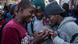 A group of boys look at something on their phone A group of boys look at something on their phone