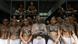 A large group of tattooed inmates stand together in a dormitory A large group of tattooed inmates stand together in a dormitory